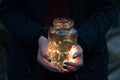 Girl holds christmas lights in glass jar Royalty Free Stock Photo