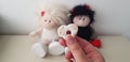 A girl holds heart shaped cookie against twin angel and devil romantic toys Royalty Free Stock Photo