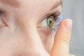 The girl holds on her finger and puts on a soft contact lens for one-day or planned replacement, the problem of myopia, poor visio Royalty Free Stock Photo