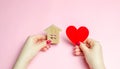 A girl holds a house and heart in her hands. The concept of affordable housing. A dream is to buy a house. Accumulation on the Royalty Free Stock Photo