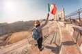 Girl holds Italian flag standing on the steps of an ancient Roman amphitheater. The concept of uniting Italy in the face of a