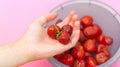 The girl holds a juicy strawberry in her hand. strawberry in her hand. Ripe, red strawberries. Soft focus. Blurred background. Royalty Free Stock Photo