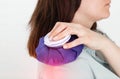 A girl holds a medical ice bag on her shoulder joint for torn and sprained ligaments, arthrosis and arthritis. Close-up