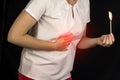 The girl holds onto her stomach and holds a burning match at the stomach level, stomach pain, heartburn