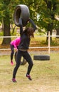 Girl holds over the head of tire.