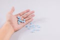 Girl holds in the palm of her hand a pill on white isolated background. medicine, paracetamol Royalty Free Stock Photo