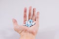 Girl holds in the palm of her hand a pill on white isolated background. medicine, paracetamol Royalty Free Stock Photo