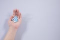 Girl holds in the palm of her hand a pill on white isolated background. medicine, paracetamol Royalty Free Stock Photo