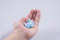 Girl holds in the palm of her hand a pill on white isolated background. medicine, paracetamol Royalty Free Stock Photo