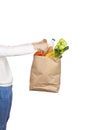 Girl holds a paper bag filled with groceries such as fruits, vegetables, milk, yogurt, eggs
