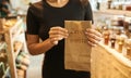 The girl holds a paper bag in her hands and demonstrates it. Plastic-free products in a waste-free shop. Zero waste concept