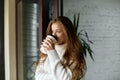 Girl holds paper cup of hot coffee. Beautiful young woman drinking latte. Royalty Free Stock Photo