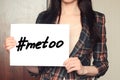 Girl holds a paper sheet with hashtag me too against harassment