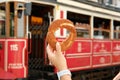 Girl holds a simit in her hand against the background of the famous red tram in Istanbul, Turkey.