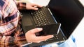 girl holds smartphone and laptop in hands, selective focus on the hand