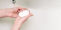 Girl holds soap in her hands. Hand washing in the sink with copy space. Coronavirus Prevention Antibacterial agent for cleaning Royalty Free Stock Photo