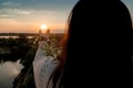 The girl holds the sun on her hand, look from the wall. End of day and summer