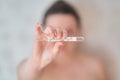 Girl holds a thermometer. High body temperature on a thermometer.