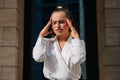 The girl holds on to her head during a headache. Beautiful fashion business lady suffers from migraines in the workplace in the