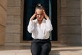 The girl holds on to her head during a headache. Beautiful fashion business lady suffers from migraines in the workplace in the