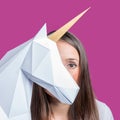 The girl holds a white 3d papercraft model of Unicorn. Minimal Art concept