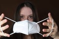 Girl holds a white medical mask, a protective respirator with a high degree of protection class FFP2, COVID-19 coronavirus, flu,