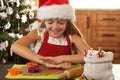 Girl in holidays mood making gingerbread cookies - cutting dough