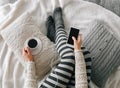 Girl home clothes smartphone cup coffee bed Royalty Free Stock Photo