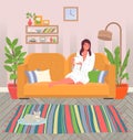 Girl at home on the couch, in a bathrobe and with a mug of tea. Cat on the mat. Cozy house Royalty Free Stock Photo