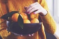 Girl at home holding bowl with winter tangerines