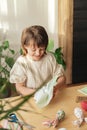 A girl at home prepares fabric for making Easter textile eggs in the shape of a hare with ears. Preparations for the