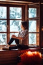 Girl in the house near the window overlooking