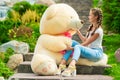 girl with a huge gift - a teddy bear in the park