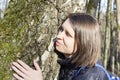 Girl hugging a huge tree trunk in the Park, smiling at the camera. The concept of protection of nature Royalty Free Stock Photo