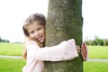 Girl hugging tree in park. Royalty Free Stock Photo