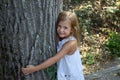 Girl hugging tree trunk