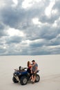 Girl hugs her boyfriend on a quad in the desert, a loving couple enjoys each other Royalty Free Stock Photo