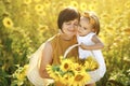 Girl hugs her grandmother holding basket of sunflowers in hand.