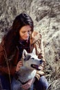 Girl husky is scratching behind the ear and smiles .