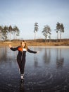 Girl ice skating on the ice of a forest lake