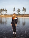 Girl ice skating on the ice of a forest lake