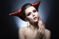 The girl in an image of the demon-tempter with long nails and haircut in the form of horns. Royalty Free Stock Photo