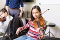 Girl Improving Violin Skills In Class
