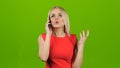 Girl indignantly talking on mobile phone on green screen Royalty Free Stock Photo