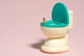 A girl infant toddler seat above potty toilet closet. Isolated on pink background