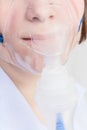 Girl inhales with face mask of nebuliser close up