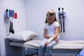Girl with injured hand sitting on stretcher bed Royalty Free Stock Photo