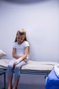 Girl with injured hand sitting on stretcher bed Royalty Free Stock Photo