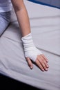 Girl with injured hand sitting on stretcher bed Royalty Free Stock Photo