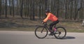 Girl intensively cycling on road bike. Woman rides on bicycle. Female pedaling on cycle. Triathlon concept